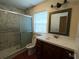 Bathroom with white and grey marble tiled shower and cherry vanity at 402 E Maple St, Winter Garden, FL 34787