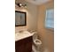 Cozy half-bathroom featuring a wood vanity, marble tile floors, and natural light at 402 E Maple St, Winter Garden, FL 34787