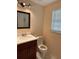 Cozy half-bathroom featuring a wood vanity, marble tile floors, and natural light at 402 E Maple St, Winter Garden, FL 34787