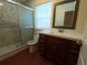 Bathroom with white and grey marble tiled shower and cherry vanity at 402 E Maple St, Winter Garden, FL 34787