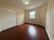 Cozy bedroom with wood floors, a window, and a double door closet at 402 E Maple St, Winter Garden, FL 34787