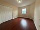 This bedroom has wood-look floors, a window, and a closet at 402 E Maple St, Winter Garden, FL 34787