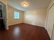Bright bedroom with hardwood floors, neutral walls, and a window letting in natural light at 402 E Maple St, Winter Garden, FL 34787