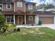 Charming two-story home with a covered front porch and attached two-car garage with a brown door at 402 E Maple St, Winter Garden, FL 34787
