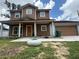 Charming two-story home with a covered front porch and attached two-car garage with a brown door at 402 E Maple St, Winter Garden, FL 34787