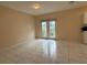 Open living room featuring neutral walls, tile flooring, and glass doors leading to the yard at 402 E Maple St, Winter Garden, FL 34787
