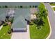 Home featuring a green roof, lush landscaping, screen porch, and a paved driveway at 425 Glen Arbor Ln, Leesburg, FL 34748