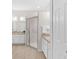 Bathroom featuring double vanities, framed mirrors, wood look tile, and glass shower enclosure at 425 Glen Arbor Ln, Leesburg, FL 34748