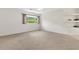 Bright, carpeted bedroom with large window and built-in shelving at 425 Glen Arbor Ln, Leesburg, FL 34748
