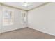 Bedroom with neutral carpet, ceiling fan, and plantation shutters on windows at 425 Glen Arbor Ln, Leesburg, FL 34748