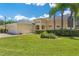 Inviting home boasts manicured lawn, mature trees, and a screened lanai for outdoor enjoyment at 425 Glen Arbor Ln, Leesburg, FL 34748