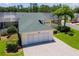 Aerial view of a charming home with a two-car garage, well-maintained lawn, and lush landscaping at 425 Glen Arbor Ln, Leesburg, FL 34748