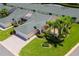 A well-maintained home featuring a green roof, lush landscaping, and a paved driveway at 425 Glen Arbor Ln, Leesburg, FL 34748