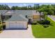 Well-maintained home featuring lush landscaping, palm trees, brick driveway, and a screened-in porch perfect for relaxation at 425 Glen Arbor Ln, Leesburg, FL 34748