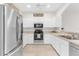 Modern kitchen featuring stainless steel appliances and white cabinetry at 425 Glen Arbor Ln, Leesburg, FL 34748