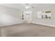 Open living room features neutral carpet, modern ceiling fan, and views of the entry and pass-through bar to kitchen at 425 Glen Arbor Ln, Leesburg, FL 34748