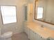 This bathroom has a vanity with cabinets, a large mirror, and wallpapered walls at 432 Santa Fe E Rd, Tavares, FL 32778