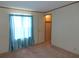 This bedroom features light-colored walls, carpeted floor, and a window with blue curtains at 432 Santa Fe E Rd, Tavares, FL 32778
