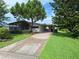 Charming single-story home with a long driveway, mature trees and a screened in porch at 432 Santa Fe E Rd, Tavares, FL 32778