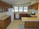 A functional kitchen with wood cabinets, white appliances and an eat-in countertop at 432 Santa Fe E Rd, Tavares, FL 32778