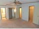 Spacious main bedroom featuring neutral carpeting, a ceiling fan, and large closets at 432 Santa Fe E Rd, Tavares, FL 32778