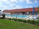 Fenced community pool surrounded by lush landscaping, seating and umbrellas at 432 Santa Fe E Rd, Tavares, FL 32778