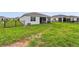 Well-maintained backyard with a green lawn, partial fence, and screened in lanai at 4701 Nw 51St Terrace Rd, Ocala, FL 34482