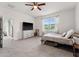 Spacious bedroom with a ceiling fan, television, and large window overlooking backyard at 4701 Nw 51St Terrace Rd, Ocala, FL 34482