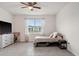 Bedroom featuring a ceiling fan, dresser with TV, and a large window with outside view at 4701 Nw 51St Terrace Rd, Ocala, FL 34482