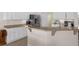 Open kitchen with bar seating, white cabinets, stainless refrigerator, and tile flooring at 4826 Sable Ridge Ct, Leesburg, FL 34748