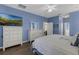 Bright bedroom features a ceiling fan, ensuite bathroom, and wood-look floors at 4826 Sable Ridge Ct, Leesburg, FL 34748