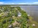 Aerial view of waterfront homes with lush trees, docks, and scenic lake views under a blue sky at 504 Banning Beach Rd, Tavares, FL 32778