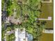 Aerial view of a home with a brick patio, lush greenery, and a private dock on the lake at 504 Banning Beach Rd, Tavares, FL 32778