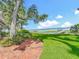 Lush backyard featuring a brick patio, green lawn, and scenic lake view with a private dock under a blue sky at 504 Banning Beach Rd, Tavares, FL 32778