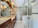 Bathroom showcasing a vanity, framed mirror, tiled shower, and floral wallpaper at 504 Banning Beach Rd, Tavares, FL 32778