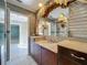 Elegant bathroom featuring a vanity with marble countertops, ornate light fixtures, and a large mirror at 504 Banning Beach Rd, Tavares, FL 32778