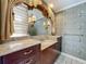 Bathroom featuring custom vanity, decorative mirror, and floral wallpaper at 504 Banning Beach Rd, Tavares, FL 32778