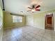 Bright bedroom featuring tile floors, closet, and a window overlooking the backyard at 504 Banning Beach Rd, Tavares, FL 32778