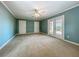 Spacious bedroom with a ceiling fan, neutral carpet and a door opening to the backyard at 504 Banning Beach Rd, Tavares, FL 32778