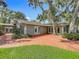 Charming home with brick patio and beautiful landscaping, featuring multiple access doors and well-maintained green lawn at 504 Banning Beach Rd, Tavares, FL 32778