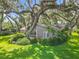 Charming home surrounded by lush landscaping, mature trees, and a well-manicured lawn at 504 Banning Beach Rd, Tavares, FL 32778