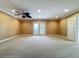 Expansive living room with neutral carpet, recessed lighting, and double doors to the backyard at 504 Banning Beach Rd, Tavares, FL 32778
