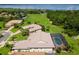 Aerial view of a home with a screened pool and a view of the lake and surrounding green space at 5418 Sandy Hill Ln, Lady Lake, FL 32159