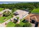 Aerial view of a home with a screened pool, a lush green lawn and surrounding neighborhood near the lake at 5418 Sandy Hill Ln, Lady Lake, FL 32159