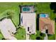 Aerial view of a home with a screened in pool surrounded by lush green lawns and mature landscaping at 5418 Sandy Hill Ln, Lady Lake, FL 32159