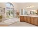 Bright bathroom with dual sinks, vanity and soaking tub with view at 5418 Sandy Hill Ln, Lady Lake, FL 32159