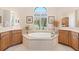 Bright bathroom showcasing a large soaking tub beneath a window with abundant natural light at 5418 Sandy Hill Ln, Lady Lake, FL 32159
