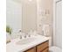 Bathroom sink with wood cabinets and white counter, with decor and a wall mirror at 5418 Sandy Hill Ln, Lady Lake, FL 32159