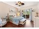 Bedroom with ceiling fan, wood floors, and sliding glass doors leading to a patio at 5418 Sandy Hill Ln, Lady Lake, FL 32159