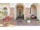 Inviting front entrance with stone accents, an arched doorway, and decorative plants at 5418 Sandy Hill Ln, Lady Lake, FL 32159